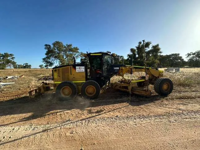 Motor grader trimming a road subgrade